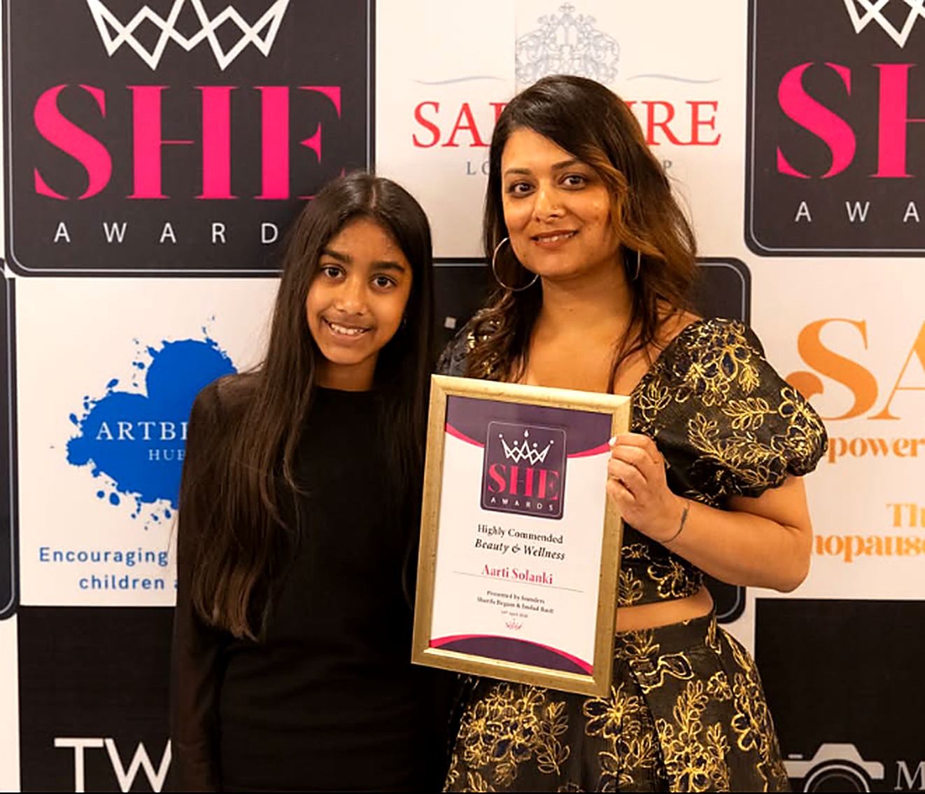 Aarti and Yana Solanki holding their SHE Awards 2026 Highly Commended certificate for Beauty & Wellness
